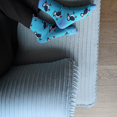 Person wearing blue socks on a wooden floor