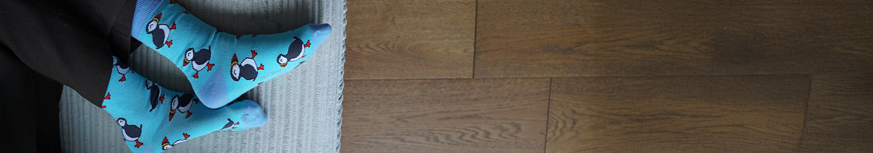 Person wearing blue socks on a wooden floor