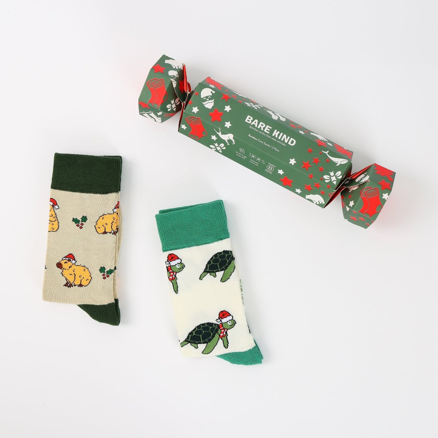 Two pairs of socks with animal patterns and a 'Bare Kind' branded box on a white background