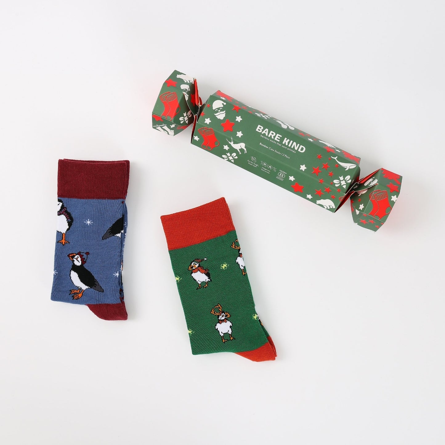 Two pairs of socks with animal patterns and a 'Bare Kind' branded box on a white background