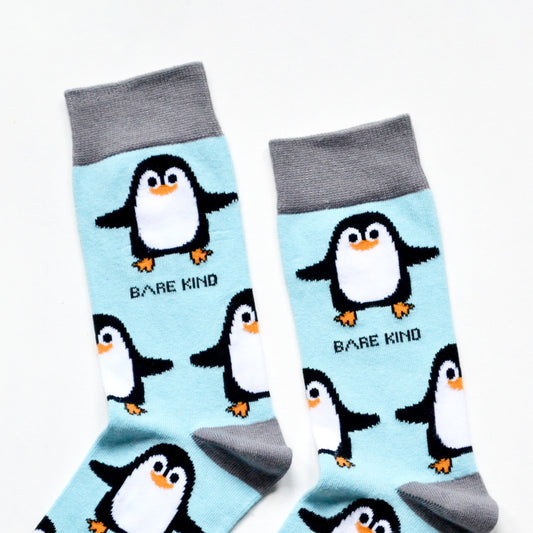 cuff closeup flat lay of sky blue bamboo socks with woven penguin design