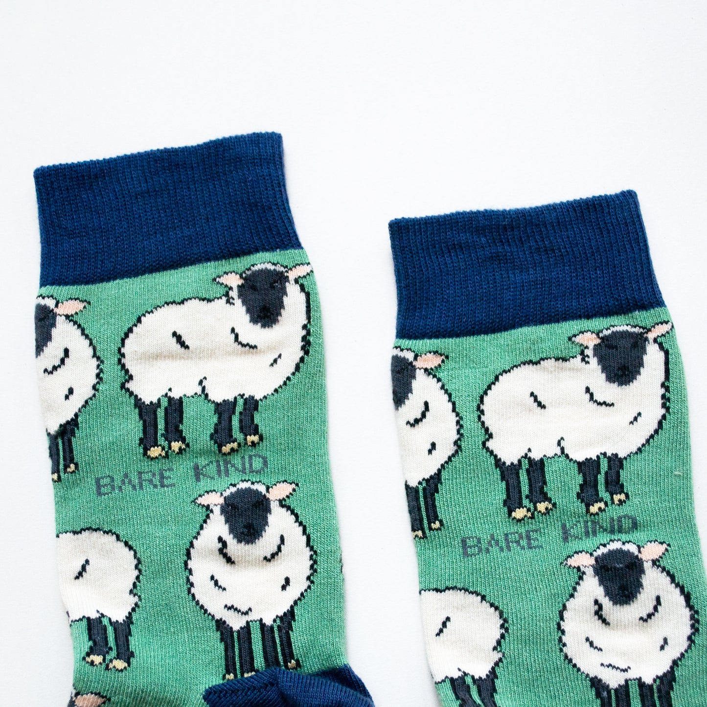 cuff closeup flat lay of green sheep socks with navy cuff
