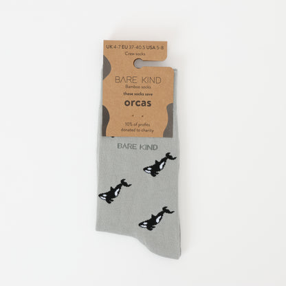 Flat lay of Bare Kind bamboo socks packaging, featuring small motifs of orcas