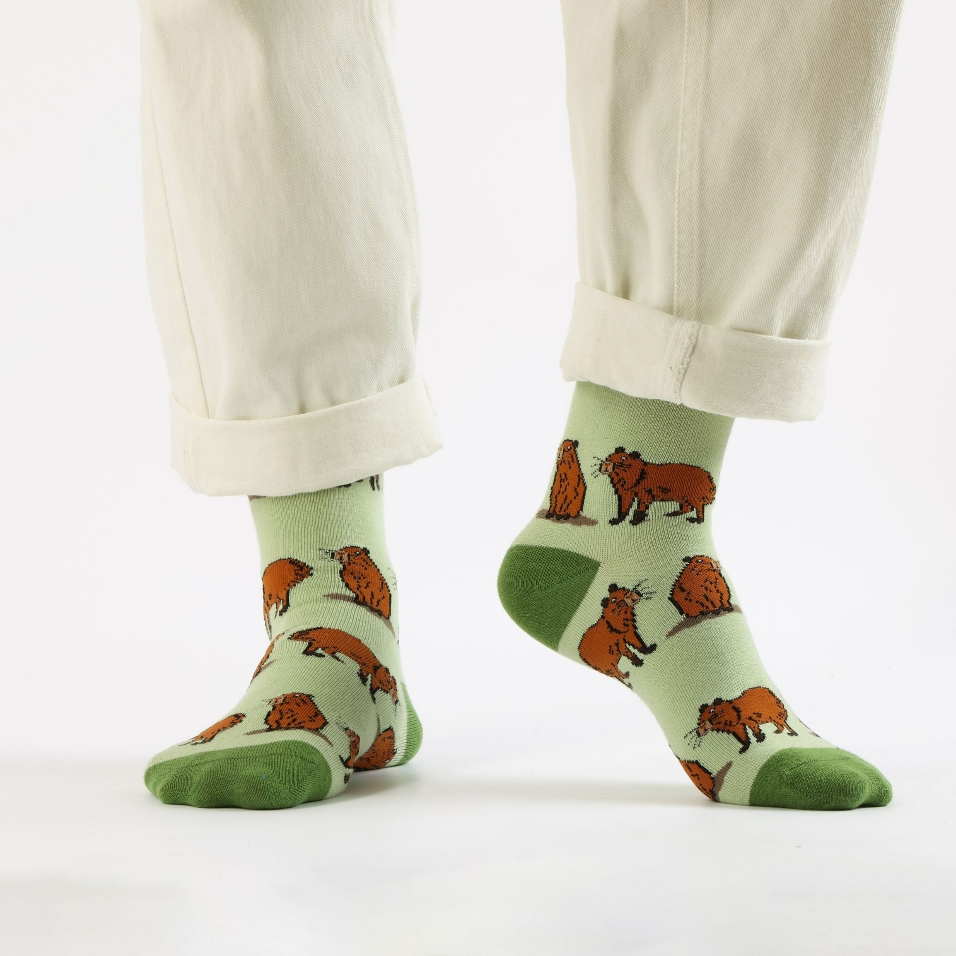 Green capybara bamboo sock worn by a person on a white background