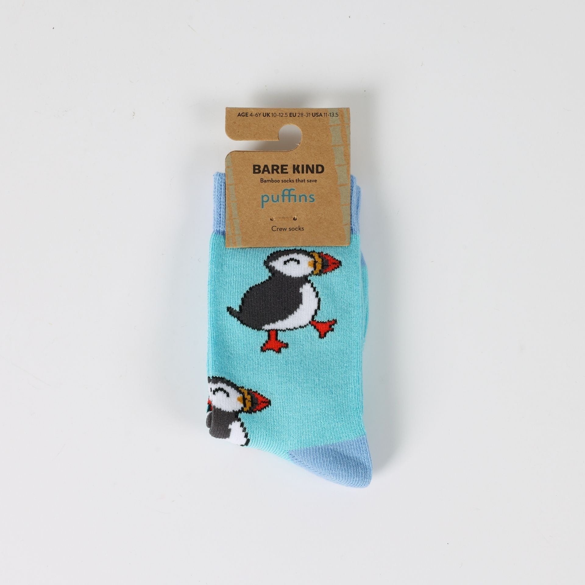 Pair of socks with puffin design and Bare Kind packaging on a light gray background