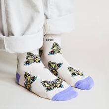 standing model wearing butterfly socks, side angle view