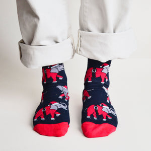 standing model wearing christmas elephant socks, front view