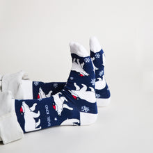 sitting model wearing polar bear christmas socks, featuring a series of crawling polar bears with santa's hat on