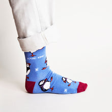side view of standing model wearing cobalt christmas socks in puffin design