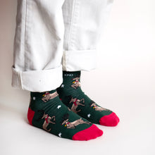 standing model wearing christmas reindeer socks, side angle view