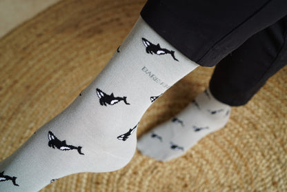 Model wearing Bare Kind bamboo socks packaging, featuring small motifs of orcas