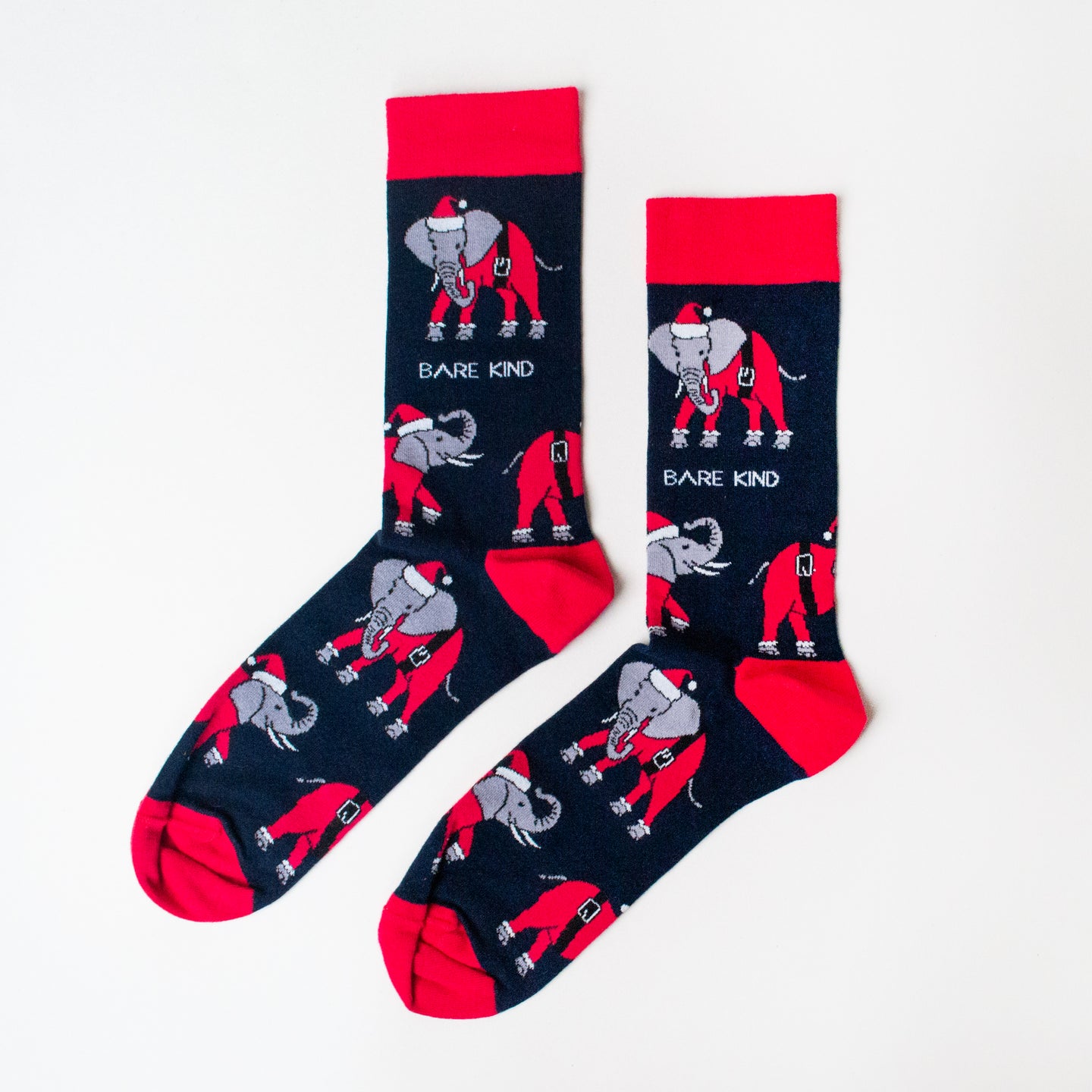 flat lay of navy and red christmas socks featuring an elephant wearing a santa outfit