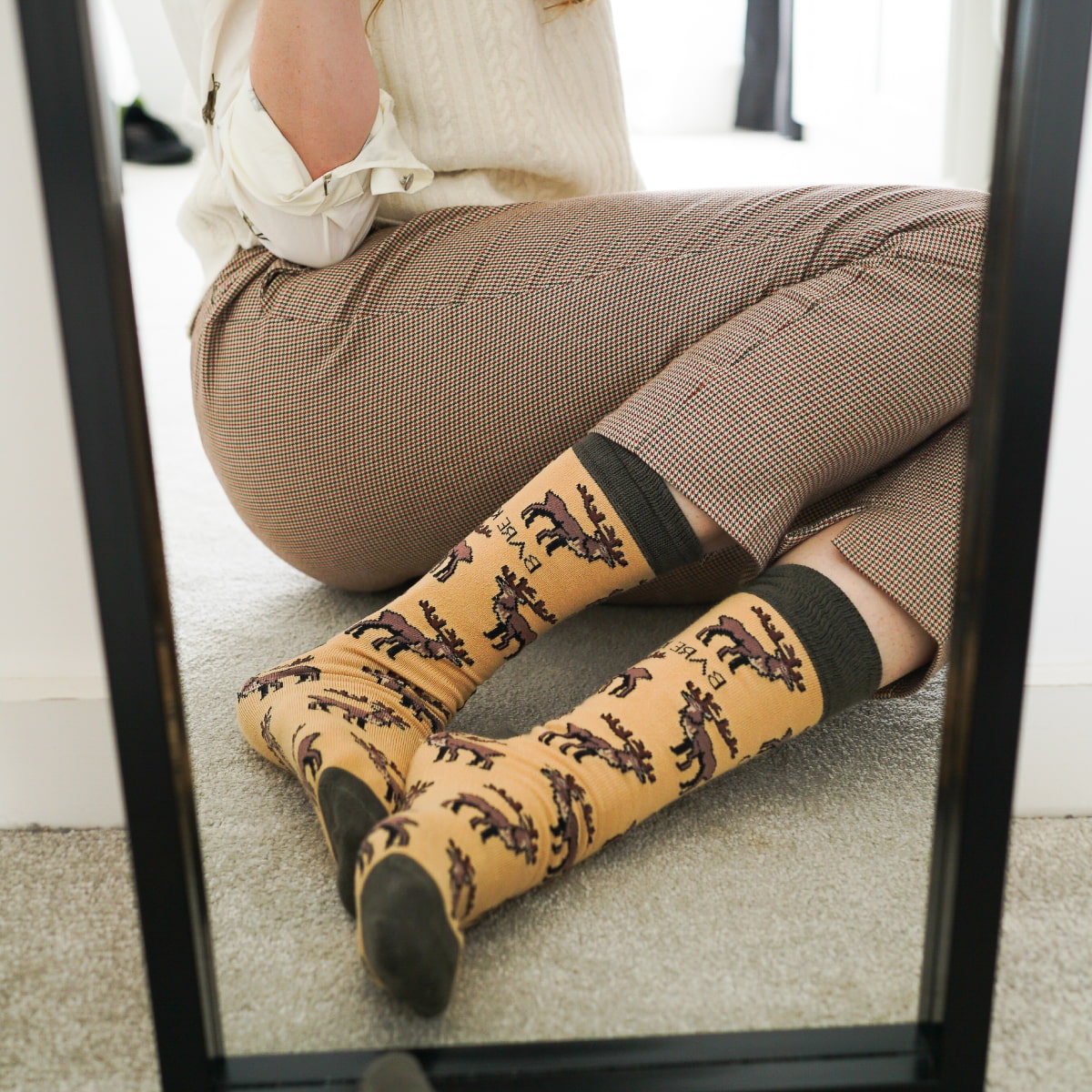 Model wearing highland deer bamboo socks in front of mirror