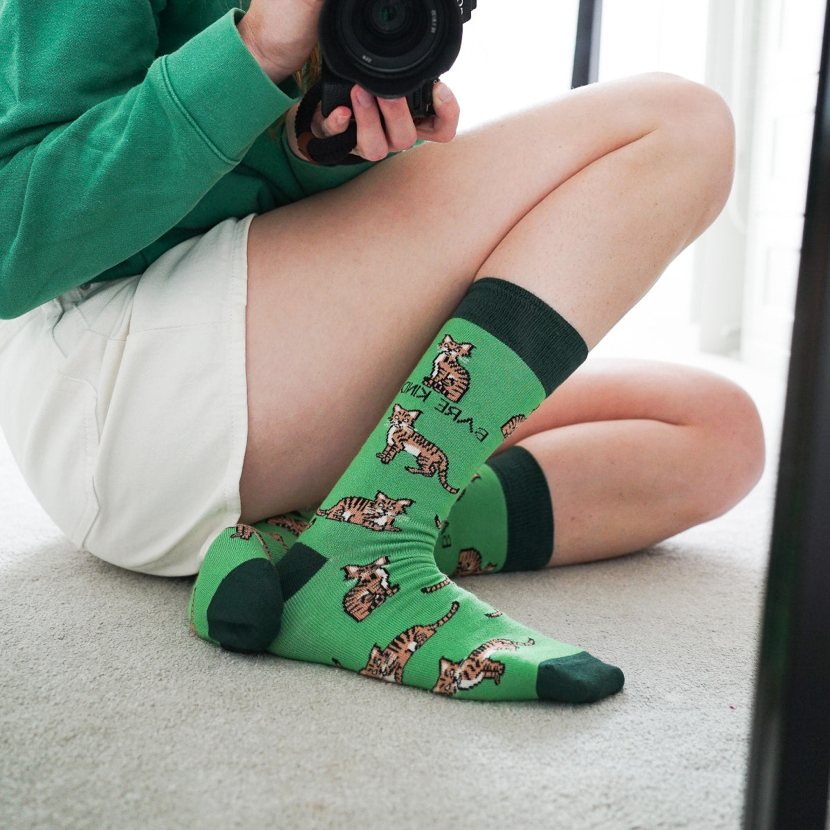 Model wearing highland wild cat bamboo socks in front of mirror