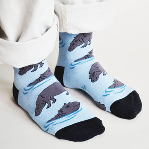 standing model wearing hippo socks, side angle view