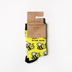 folded flat lay of yellow and black bamboo bee socks for kids in 100% recyclable cardboard packaging
