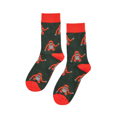 A pair of dark green crew socks with bright orange cuffs, heels, and toes, featuring a repeating pattern of orangutans in orange and gray.