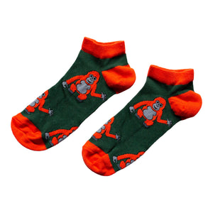 flat lay of dark green and red ankle trainer socks featuring orangutan design