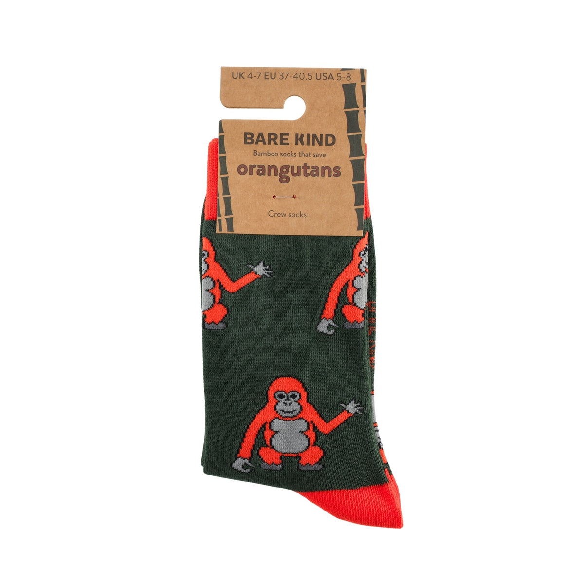 A pair of Bare Kind orangutans crew socks with a dark green base, featuring cartoon orangutan prints in red and gray, with a red toe cap and a brown cardboard hanger.