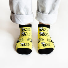 standing model wearing yellow and black bee ankle socks
