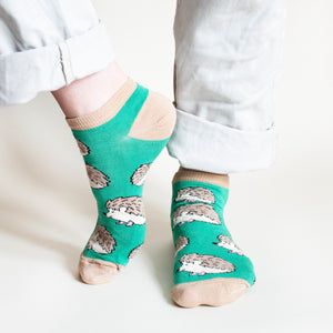 standing model wearing green hedgehog ankle trainer socks