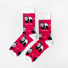 flat lay of red and white christmas socks featuring a panda wearing a reindeer headdress 