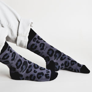 side profile view of sitting model wearing black panther print bamboo socks