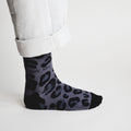 side profile view of standing model wearing black panther print bamboo socks