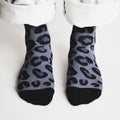 front profile view of standing model wearing black panther print bamboo socks