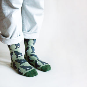 side angle view of standing model wearing green wolf bamboo socks