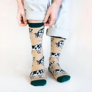 standing model pulling up the dark green cuff of beige bamboo cow socks