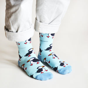 side angle view of standing model wearing blue puffin bamboo socks
