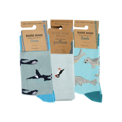 Three pairs of socks with animal designs on packaging labeled 'Bare Kind'.