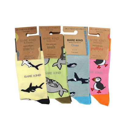 Four pairs of socks with animal designs and 'Bare Kind' branding on cardboard packaging.