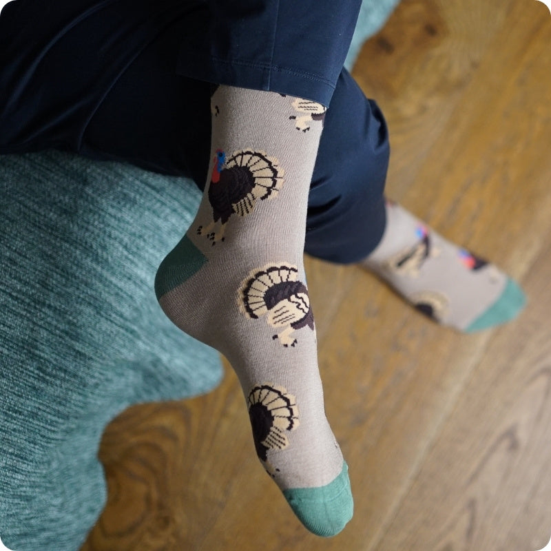 Person wearing turkey sock with on a wooden floor