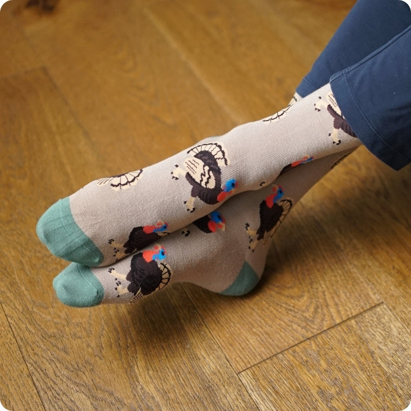 Person wearing turkey socks on a wooden floor