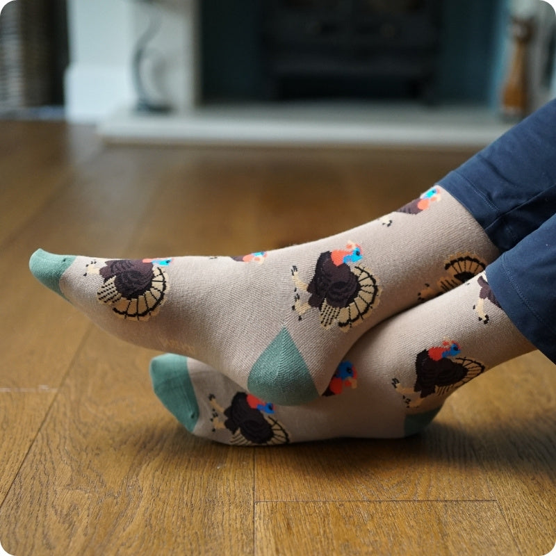 Person wearing turkey socks on a wooden floor