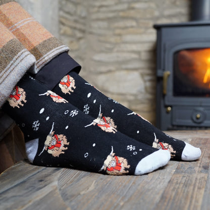 lifestyle image of model wearing black christmas highland cow bamboo socks