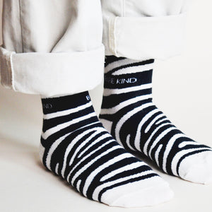 side angle view of standing model wearing zebra print socks