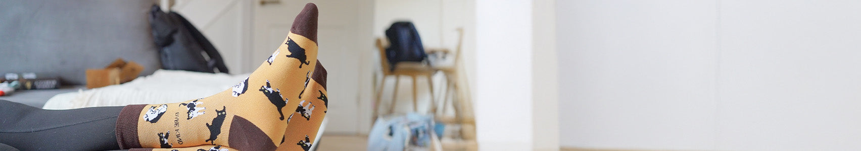 Person wearing a sock with cat pattern in a room setting