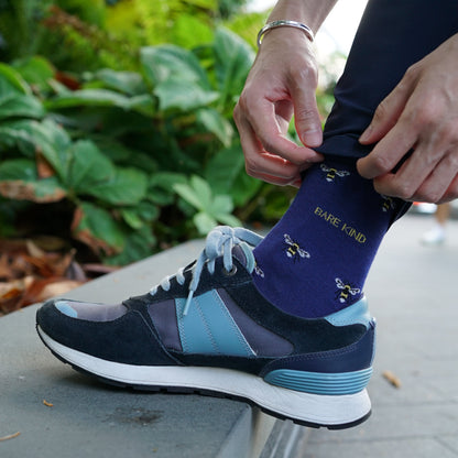 Model wearing Bare Kind bamboo socks, featuring small motifs of bees