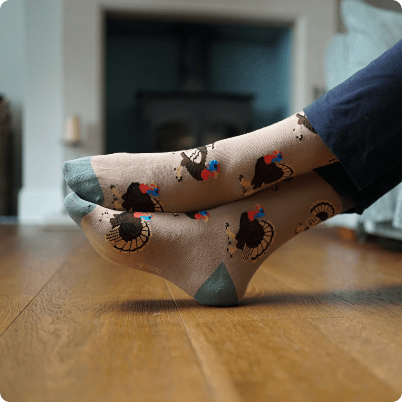 Person wearing Turkey bamboo socks on a wooden floor with a blurred background