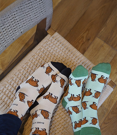 Two people wearing green and brown capybara socks