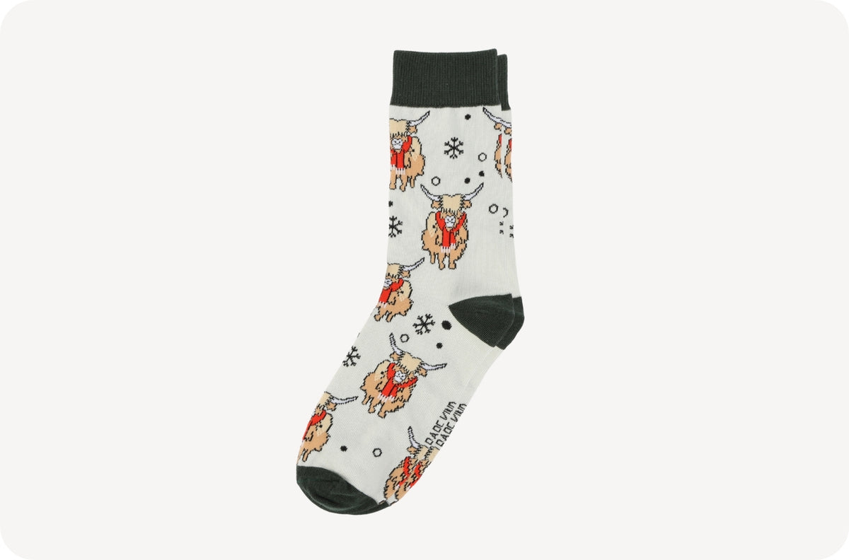 A single crew sock with a white background featuring a cartoon Highland cow pattern in orange, red, and black, with solid black heels, toes, and cuffs.