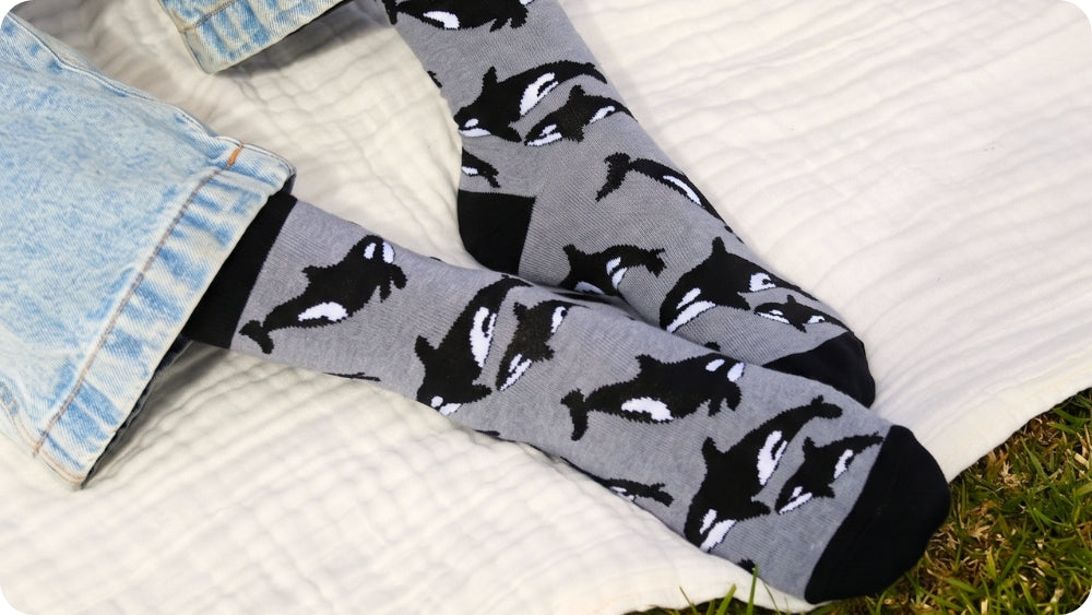 Gray socks with orca whale pattern on a white surface