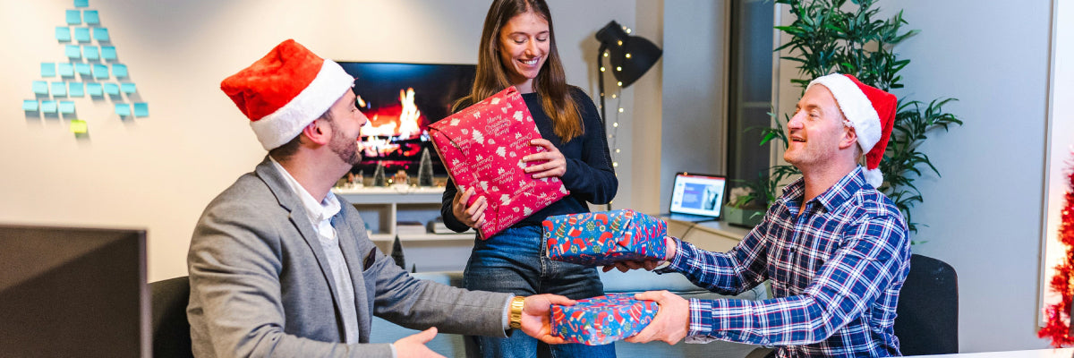 work mates giving Christmas gifts to each other