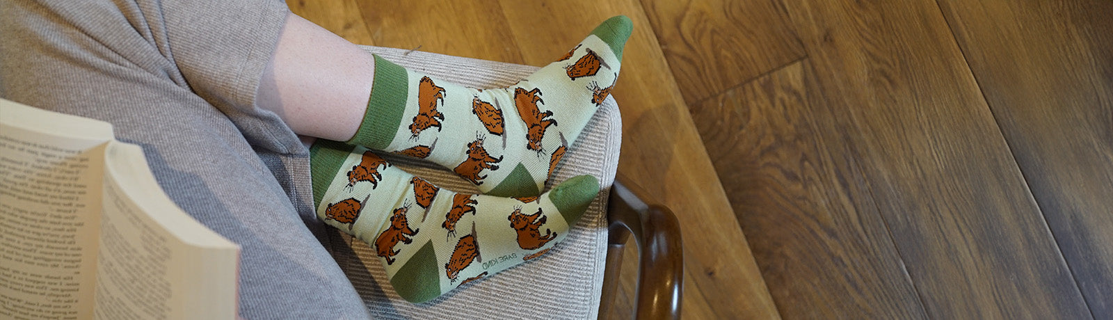 Person wearing green socks with capybara design.