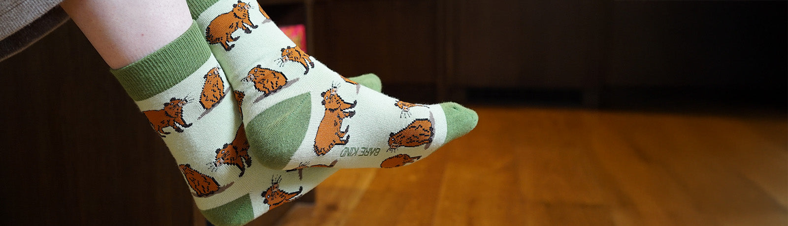 Person wearing green socks with capybara design.