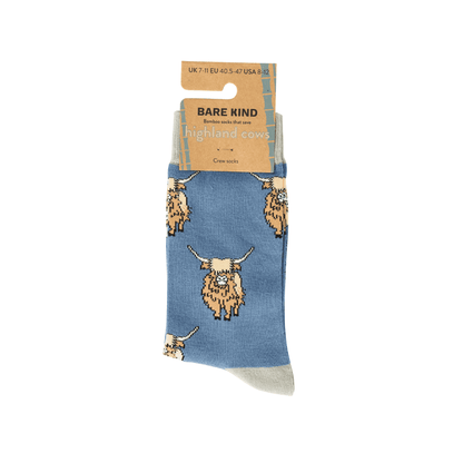 Blue sock with highland cow pattern on a white background, featuring Bare Kind packaging.