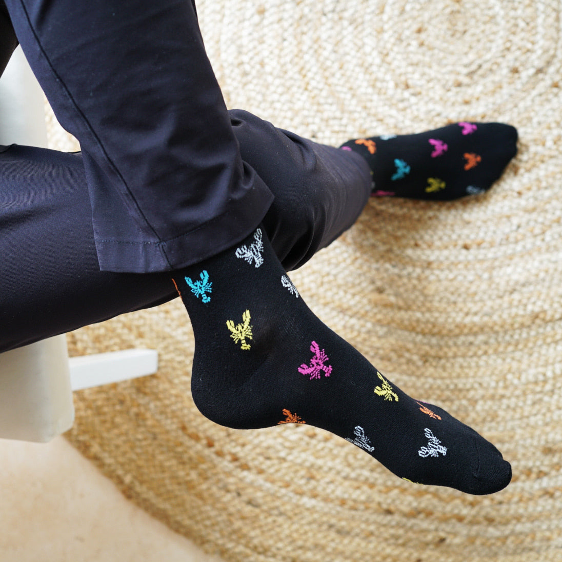 Model wearing Bare Kind bamboo socks, featuring small motifs of lobsters